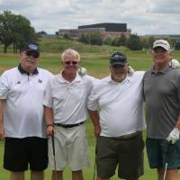 4 men pose for pic on course
